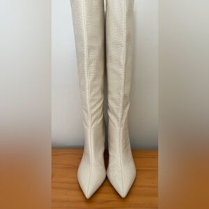 Womans cream colored heeled tall boot.
